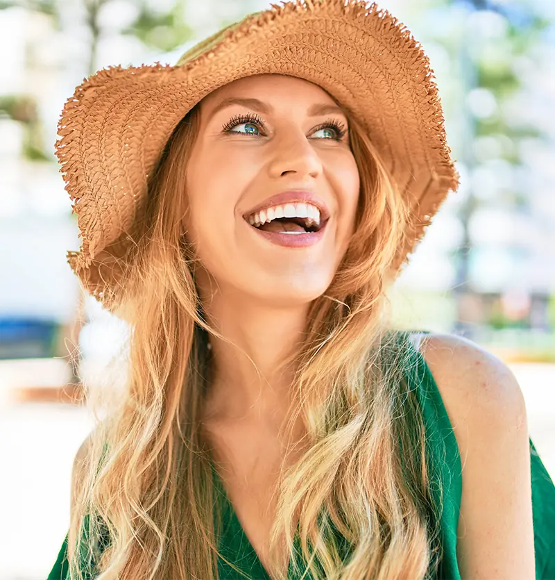 Happy blonde woman wearing straw hat