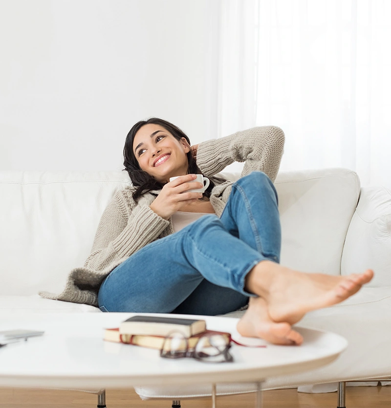 Woman relaxing on couch with cup of tea