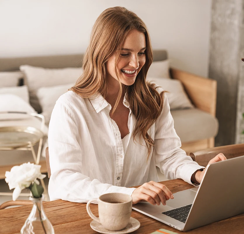Young cheerful woman looking at laptop